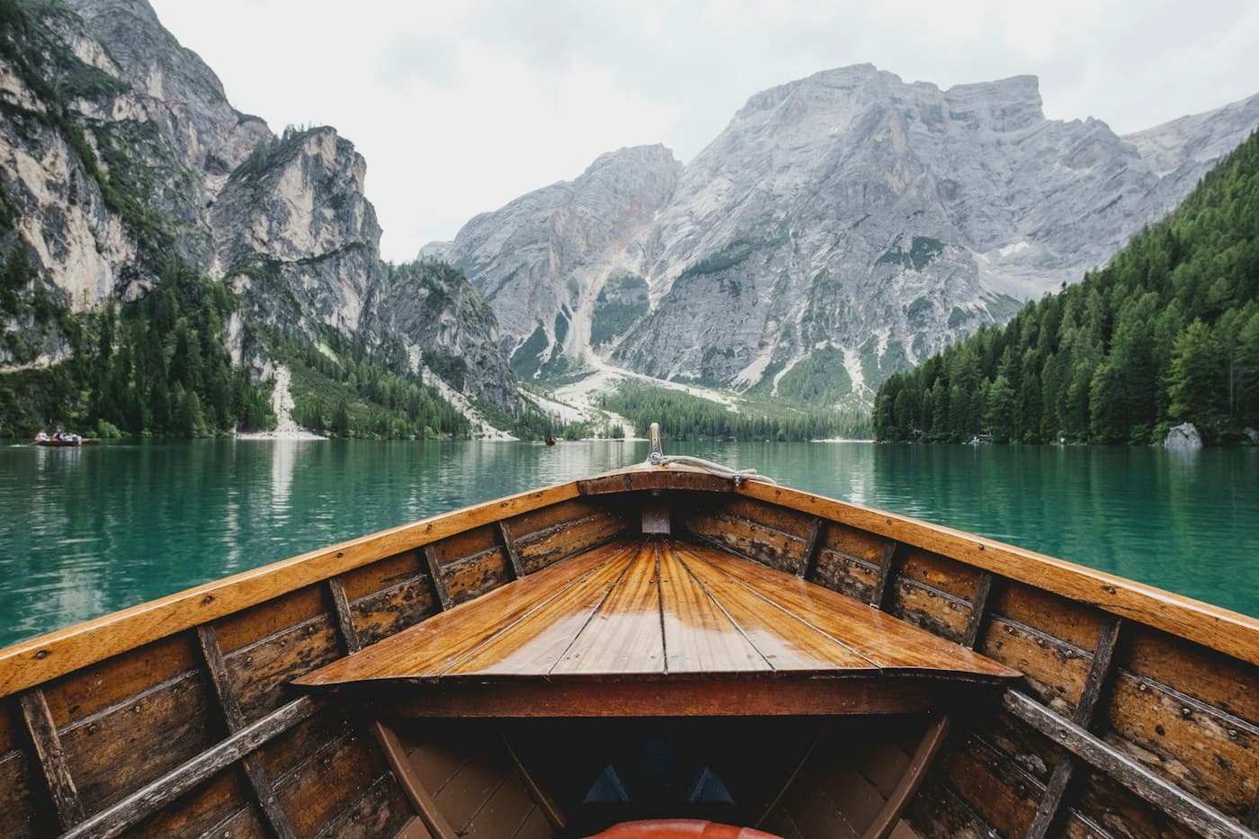 An alpine lake, little boats, and mountains stretching into the distance